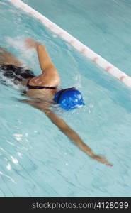 High angle view of a teenage girl swimming in a swimming pool