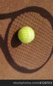 High angle view of a tennis ball on the shadow of a tennis racket