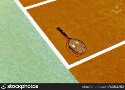 High angle view of a tennis racket and tennis balls in a tennis court