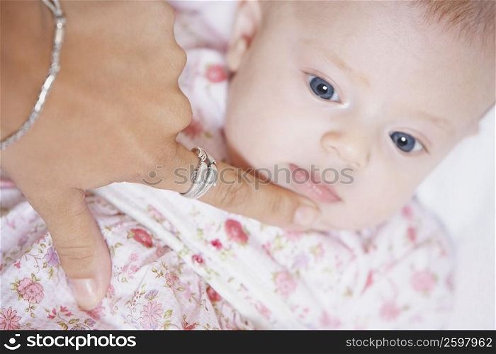 High angle view of a woman&acute;s finger touching the chin of a baby girl