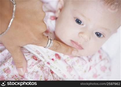 High angle view of a woman&acute;s finger touching the chin of a baby girl