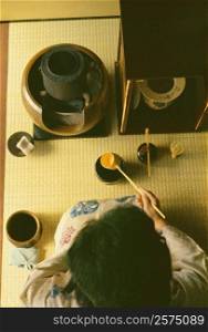 High angle view of a woman making tea, Tokyo Prefecture, Japan