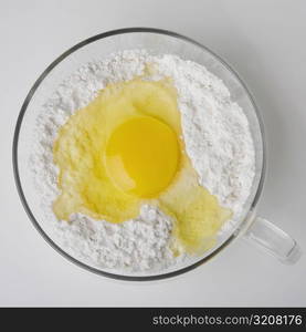 High angle view of a yolk in cup of flour