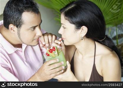 High angle view of a young couple drinking a glass of juice
