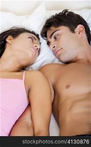 High angle view of a young couple looking at each other on a bed