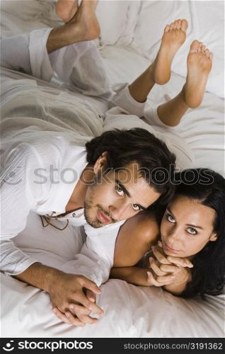 High angle view of a young couple lying down on a bed