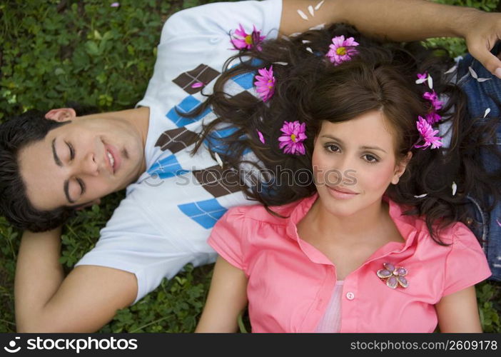 High angle view of a young couple lying in a park