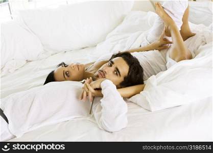 High angle view of a young couple lying on the bed