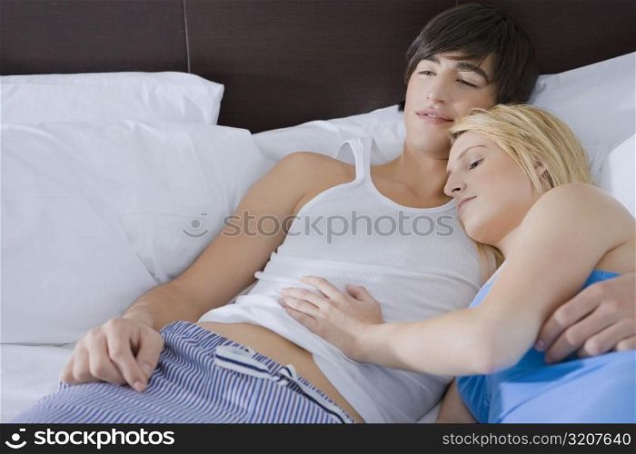 High angle view of a young couple lying on the bed