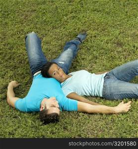 High angle view of a young couple lying on the grass