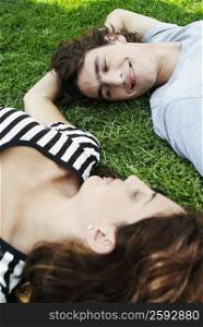 High angle view of a young couple lying on the grass in a park