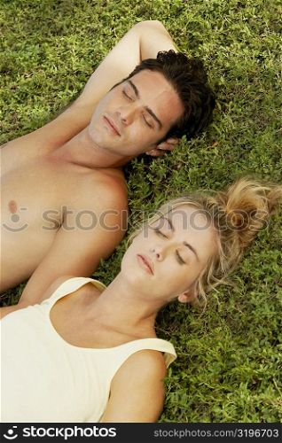 High angle view of a young couple lying on the lawn
