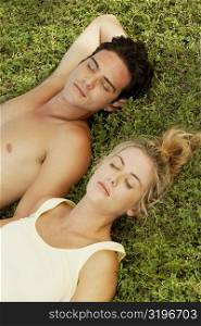 High angle view of a young couple lying on the lawn
