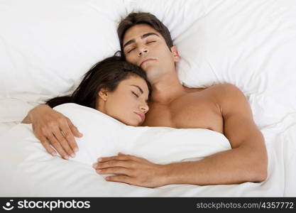 High angle view of a young couple sleeping on a bed