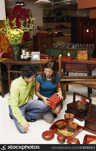 High angle view of a young man and a young couple choosing merchandise in a store