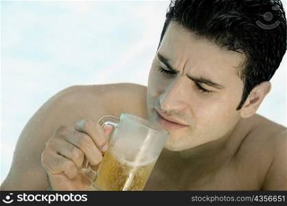 High angle view of a young man holding a mug of beer