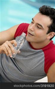 High angle view of a young man holding a water bottle