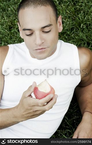 High angle view of a young man holding an apple