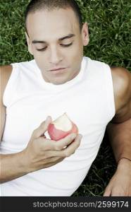 High angle view of a young man holding an apple