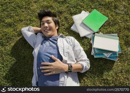 High angle view of a young man lying in a lawn