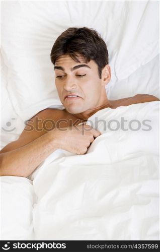 High angle view of a young man lying on the bed