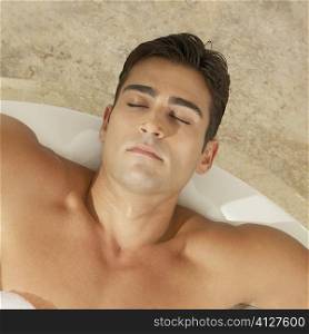 High angle view of a young man relaxing in the bathtub