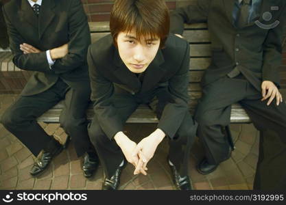 High angle view of a young man sitting on a bench