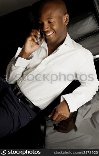 High angle view of a young man using a mobile phone and smiling