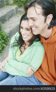 High angle view of a young woman and a mid adult man embracing each other and smiling