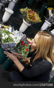 High angle view of a young woman arranging bouquets at a flower shop