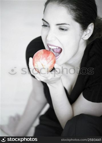 High angle view of a young woman eating an apple