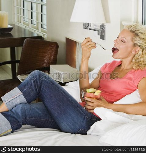 High angle view of a young woman eating fruit salad