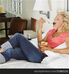 High angle view of a young woman eating fruit salad