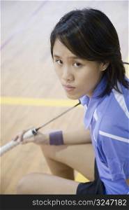 High angle view of a young woman holding a badminton racket