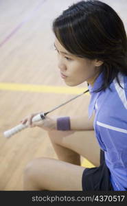 High angle view of a young woman holding a badminton racket