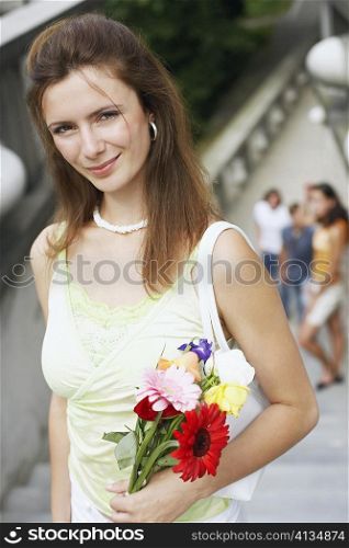 High angle view of a young woman holding a bouquet of flowers