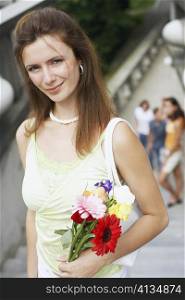 High angle view of a young woman holding a bouquet of flowers