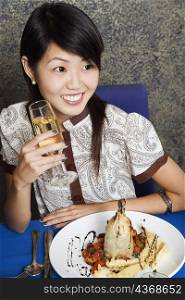 High angle view of a young woman holding a glass of champagne in a restaurant
