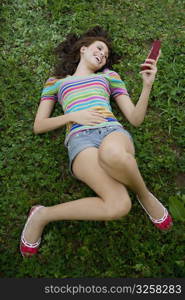 High angle view of a young woman holding a mobile phone and laughing