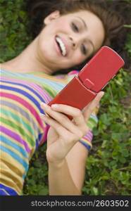 High angle view of a young woman holding a mobile phone and smiling