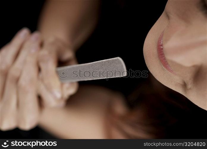 High angle view of a young woman holding a nail file