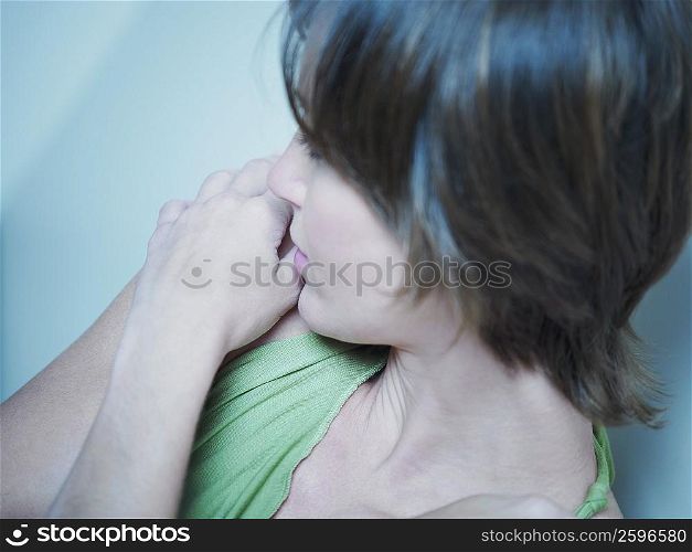 High angle view of a young woman hugging herself