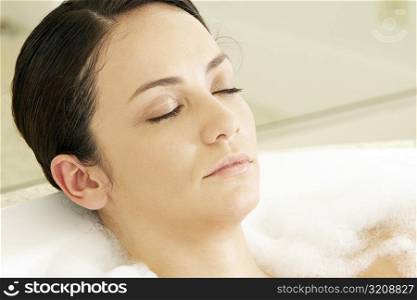 High angle view of a young woman in a bathtub with her eyes closed