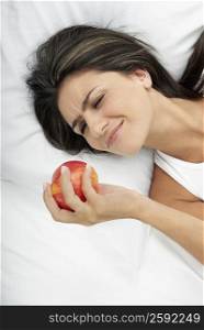 High angle view of a young woman looking at an apple