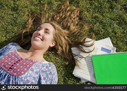 High angle view of a young woman lying in a lawn