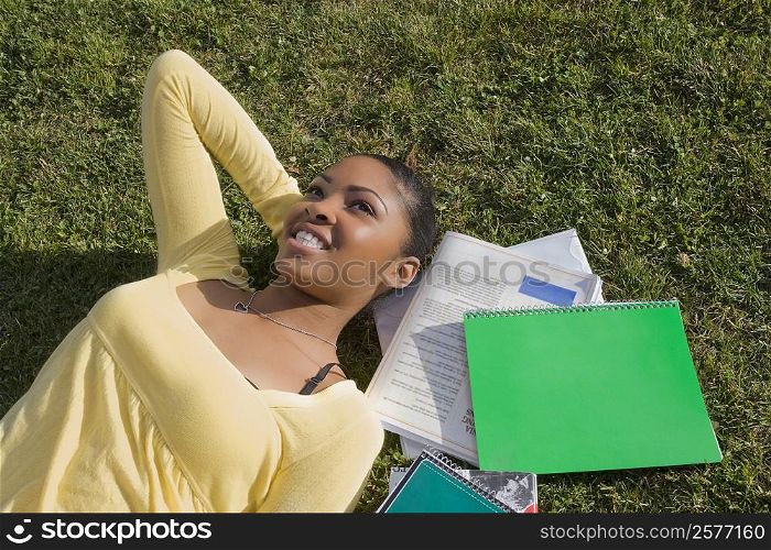 High angle view of a young woman lying in a lawn and day dreaming
