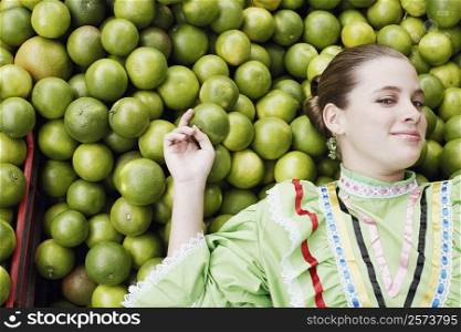 High angle view of a young woman lying on a heap of tangerines