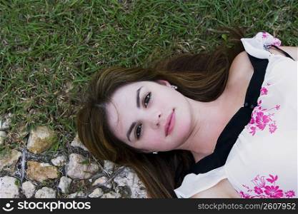 High angle view of a young woman lying on grass