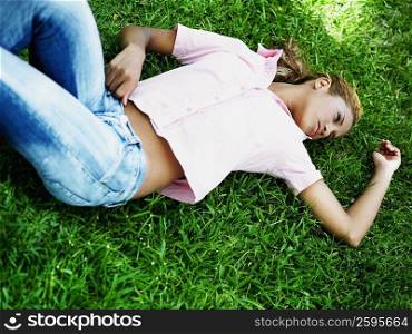 High angle view of a young woman lying on the grass