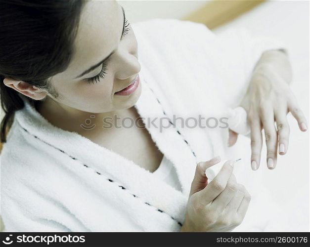 High angle view of a young woman polishing her nails